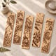 Five engraved bookmarks with a dragonfly, mushroom, open book and forest