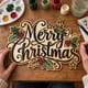 Hands painting the Merry Christmas holly script sign at a craft table