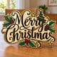 Painted Merry Christmas holly script sign standing on a wooden table