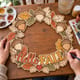 Hands painting the Hello Fall acorn wreath at a craft table
