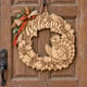 Unpainted wooden fall Welcome wreath with a cheerful turkey hanging on a front door