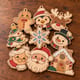 Nine painted Christmas ornaments including Santa, a snowman, a penguin and a gingerbread cottage