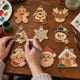 Hands painting a set of nine wooden Christmas ornaments at a craft table