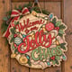 Painted round Welcome to Our Jolly Chaos sign hanging on a wooden front door