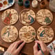 Hands painting nativity Christmas carol ornaments at a craft table
