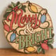 Painted round Merry and Bright sign with retro Christmas lights standing on a wooden table