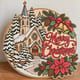 Painted round Merry Christmas sign with a snowy church standing on a wooden table