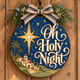Painted round Oh Holy Night sign with the Star of Bethlehem hanging on a wooden front door