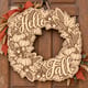 Unpainted wooden Hello Fall pumpkin and wheat wreath hanging on a front door