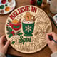 Hands painting the round Believe in the Spirit of Christmas cocktail sign at a craft table