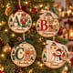 Painted alphabet name ornaments hanging on a Christmas tree