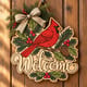 Painted cardinal winter welcome door hanger hanging on a wooden front door