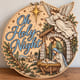Painted round Oh Holy Night nativity sign with an angel and the Holy Family standing on a wooden table