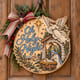 Painted round Oh Holy Night nativity sign with an angel and the Holy Family hanging on a wooden front door