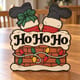 Painted Ho Ho Ho Santa chimney door hanger standing on a wooden table