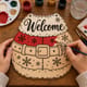 Hands painting the Santa belt welcome door hanger at a craft table