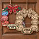 Painted and unpainted kawaii dumpling Christmas wreaths hanging side by side on a wooden door