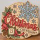 Painted round Christmas Countdown sign with a large snowflake standing on a wooden table