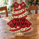 Painted Tis the Season Christmas tree door hanger standing on a wooden table