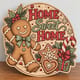 Painted round gingerbread man Home Sweet Home sign standing on a wooden table