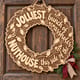 Unpainted wooden Christmas lights wreath with humorous jolliest bunch nuthouse lettering hanging on a front door