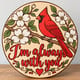 Painted round cardinal memorial sign reading I'm always with you standing on a wooden table