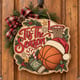 Painted round basketball Christmas sign with a Santa hat hanging on a wooden front door