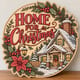 Painted round Home for Christmas sign with a snowy cottage standing on a wooden table